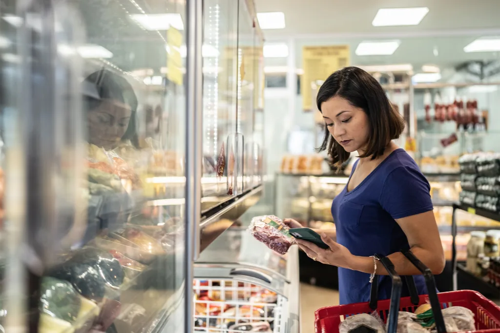 Woman In Store Looking At Phone